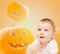 Smiling baby over pumpkins background