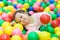 Smiling baby playing in the balls pool. Cute and happy girl. Picture for developmental in children concept.