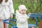 Smiling baby toddler rides carousel in playground outside. Concept of kindergarten and childhood