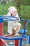 Smiling baby toddler rides carousel in playground outside. Concept of kindergarten and childhood