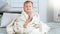 Smiling baby in white towel after having bath sitting on bed