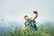 Smiling backpacker man taking selfie picture using smartphone and showing Thumbs Up during walking by the foggy cloudy weather