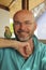 Smiling bald man with a beard with a parrot