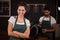 Smiling barista standing with arms crossed