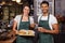 Smiling baristas holding sandwiches and hot milk