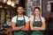 Smiling baristas standing with arms crossed