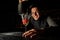 Smiling barman holding an elegant cocktail glass with splashing