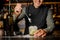 Smiling barman stirring fresh mojito in a cocktail glass