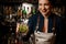 Smiling bartender girl holding an fresh cocktail with lime and mint