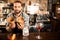 Smiling bartender holding two boxes with ingredients for cocktails