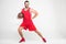 smiling basketball player in red sportswear and retro glasses posing with ball