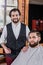 smiling bearded barber with client