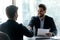 Smiling bearded businessman in suit shaking hands with job seeker.