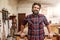 Smiling bearded craftsman in his woodwork studio