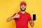 Smiling bearded delivery man in red uniform with smartphone showing thumb up