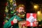 Smiling bearded man with decorated Christmas beard hold Christmas present shows thumb up. Christmas beard decorations