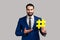 Smiling bearded man presenting yellow hashtag, tagging blog trends, viral topic in social network.