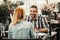 Smiling bearded man with redhead young lady at cafe