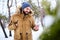 Smiling bearded man wears warm winter clothes and using smartphone with fast internet data connection in country side