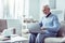 Smiling bearded retired man looking at laptop while having video chat