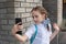 Smiling beatiful preteen girl taking a selfie outdoors. Child taking a self portrait with mobile phone. technology