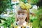 Smiling beautiful blue-eyed girl with beautiful reddish hair and a yellow bow in the Park. Childhood, nature, the concept of