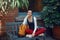 Smiling beautiful Caucasian young girl woman in white sweater and red jeans, sitting with yellow travel bag backpack on bench