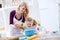 Smiling beautiful mom with child putting flour