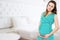 Smiling beautiful pregnant woman at home with big belly. Pregnancy and motherhood concept. Happy baby expectation. Interior