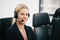 A smiling  beautiful woman sitting in a customer service department office with headset working in call center