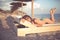Smiling beautiful woman sunbathing in a bikini on a beach at tropical travel resort