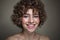 Smiling beautiful young freckled girl with curly hair, selective focus