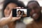 Smiling biracial couple making self-portrait picture on cell together