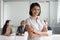 Smiling biracial female employee posing for picture in office