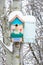 Smiling birdhouse. Birdhouse in the form of a funny face on the tree. Handmade wooden nesting box covered in snow. Winter