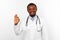 Smiling black bearded doctor man in white robe with stethoscope shows OK gesture, white background