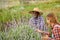 Smiling black horticulturist with unrecognizable partner against blossoming lavender plant