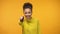 Smiling black lady pointing finger at camera, choosing winner, yellow background