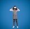 Smiling black little girl in VR glasses plays online game, has fun isolated on blue background