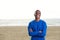 Smiling black man in blue sweatshirt at the beach