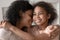 Smiling black mother and daughter embrace cuddle together