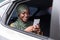 Smiling Black Muslim Lady Using Smartphone While Riding Car On Backseat
