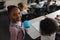 Smiling black schoolgirl standing and looking at camera in classroom