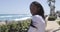 Smiling black woman sitting at seaside