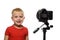 Smiling blond boy in front of the camera lens. Little video blogger. White background