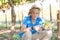 Smiling blond boy in hat harvesting ripe grapes