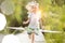 Smiling blond girl running on pier at lakeshore