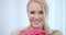 Smiling Blond Woman Smelling Pink Roses