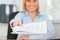 Smiling blonde businesswoman passing a paper