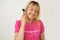 Smiling blonde doctor inbright pink medical uniform shows that otoscope examination is painless and pleasant procedure. Medical